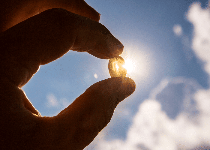 Person holding Vitamin D3 + K2 supplement capsule