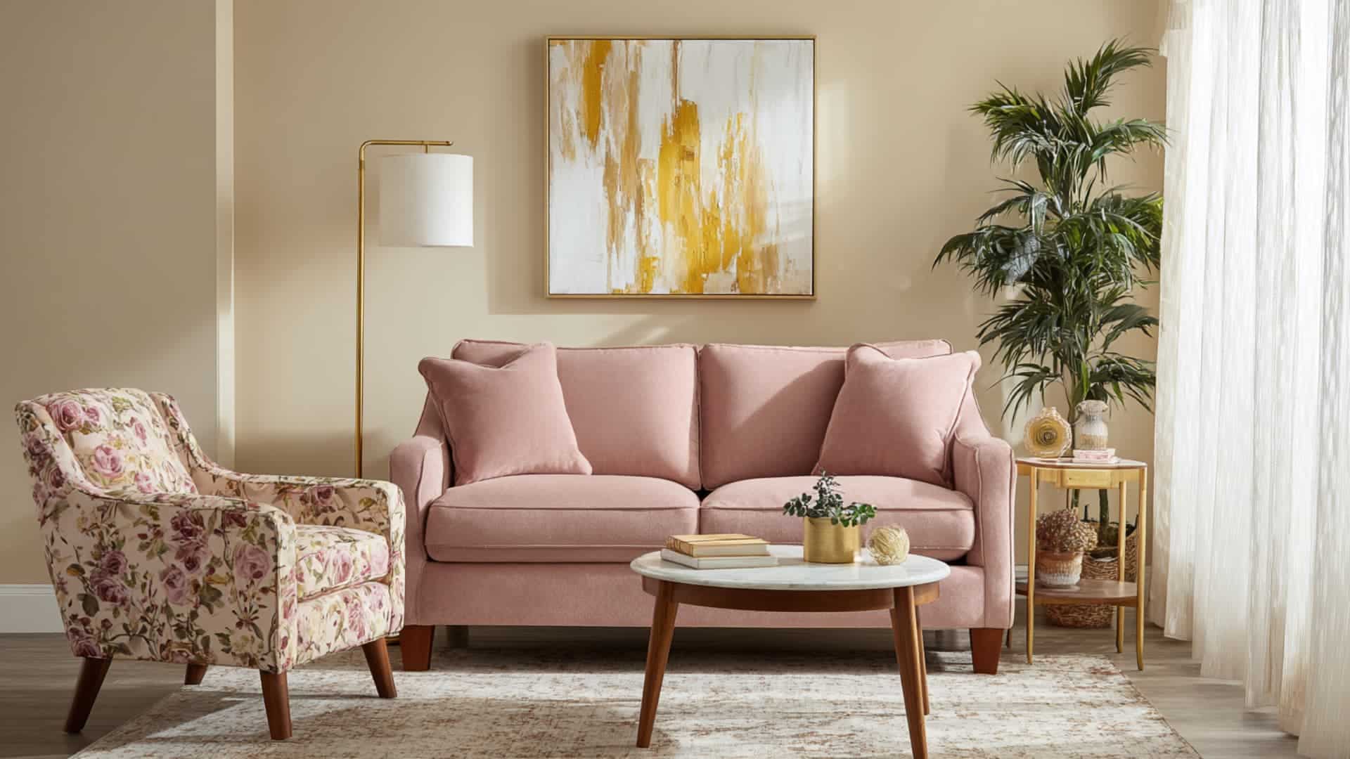 Cozy living room with large, simple wall art, blush sofa, floral chair, gold floor lamp, and soft, neutral walls.