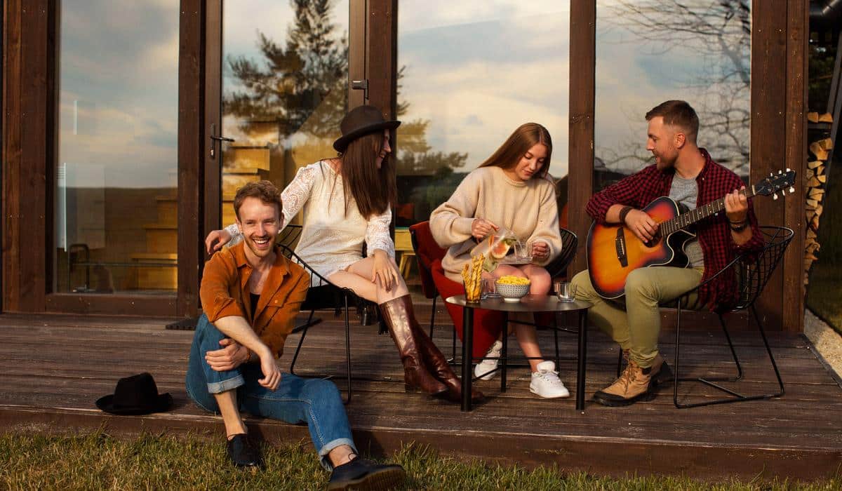 Friends relaxing and playing guitar on a wooden cabin deck