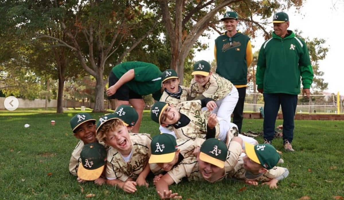 Group of young baseball players laughing in a grass field