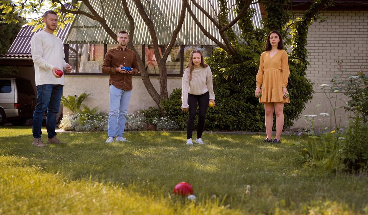 Friends playing bocce ball on a sunny green lawn