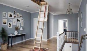 Wooden folding attic ladder extended in a modern hallway