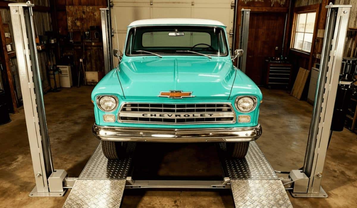 Classic teal Chevrolet pickup truck on a garage lift