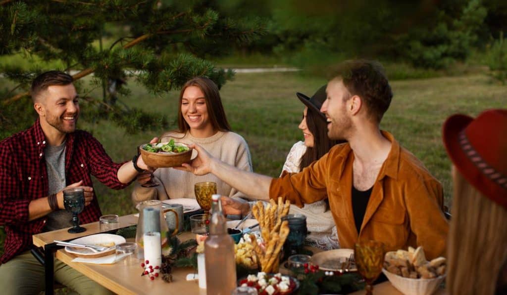 Friends sharing a salad bowl during outdoor dinner party