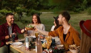 Friends sharing a salad bowl during outdoor dinner party