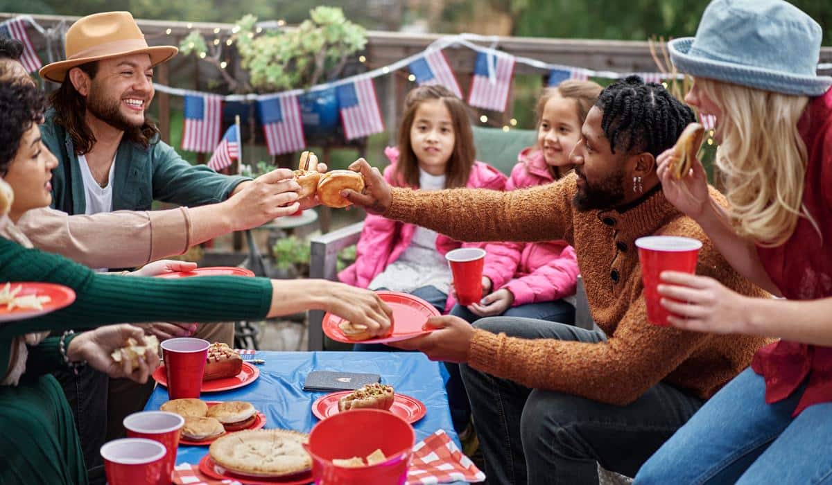 Family enjoying Fourth of July backyard barbecue with sliders