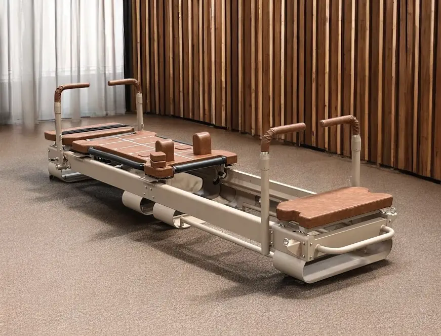 Pilates reformer machine with brown cushioning in a modern studio with wooden panel walls