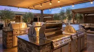 Stainless steel outdoor grills on stone islands under warm lighting in a patio setting