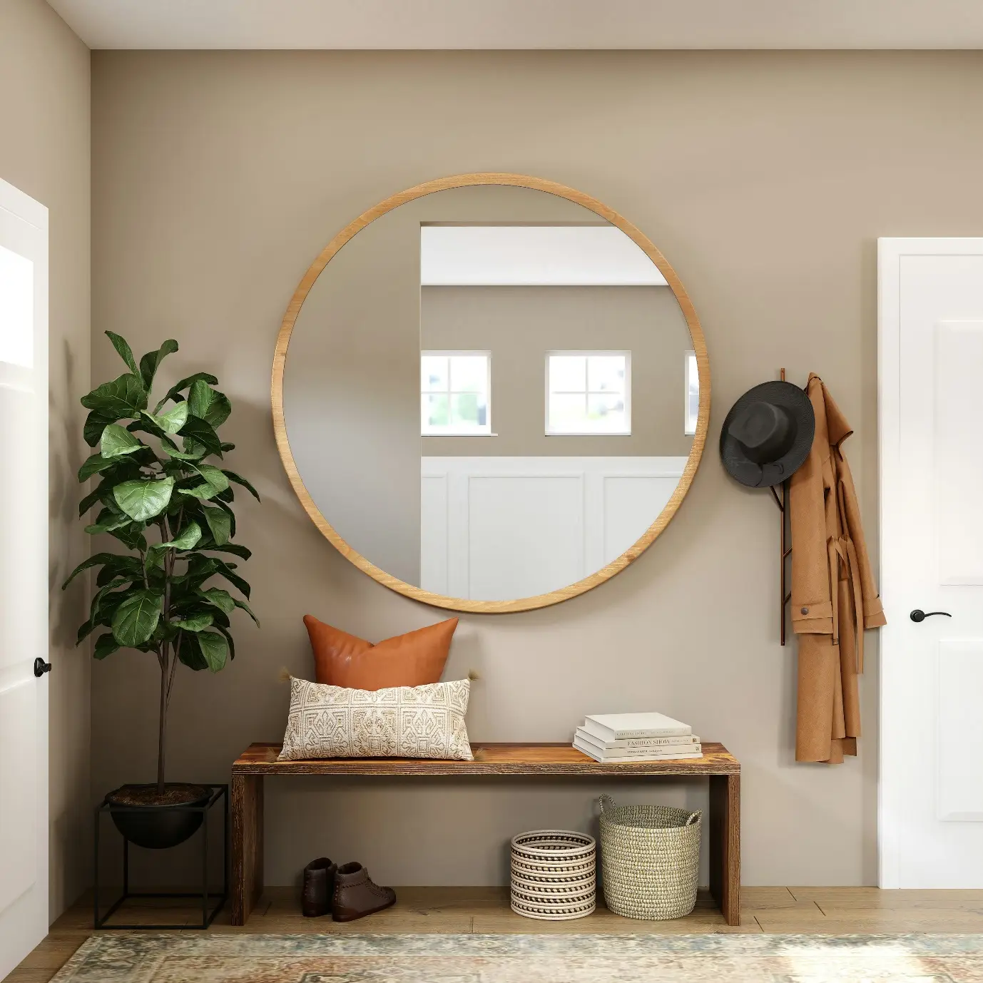 Round mirror above wooden bench with decorative pillows in cozy entryway with coat, hat, and plant