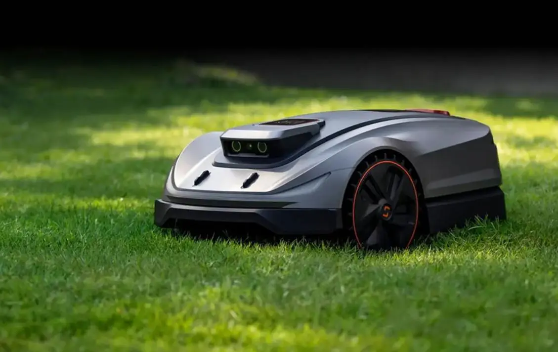 Robotic lawn mower on green grass in a sunny outdoor setting