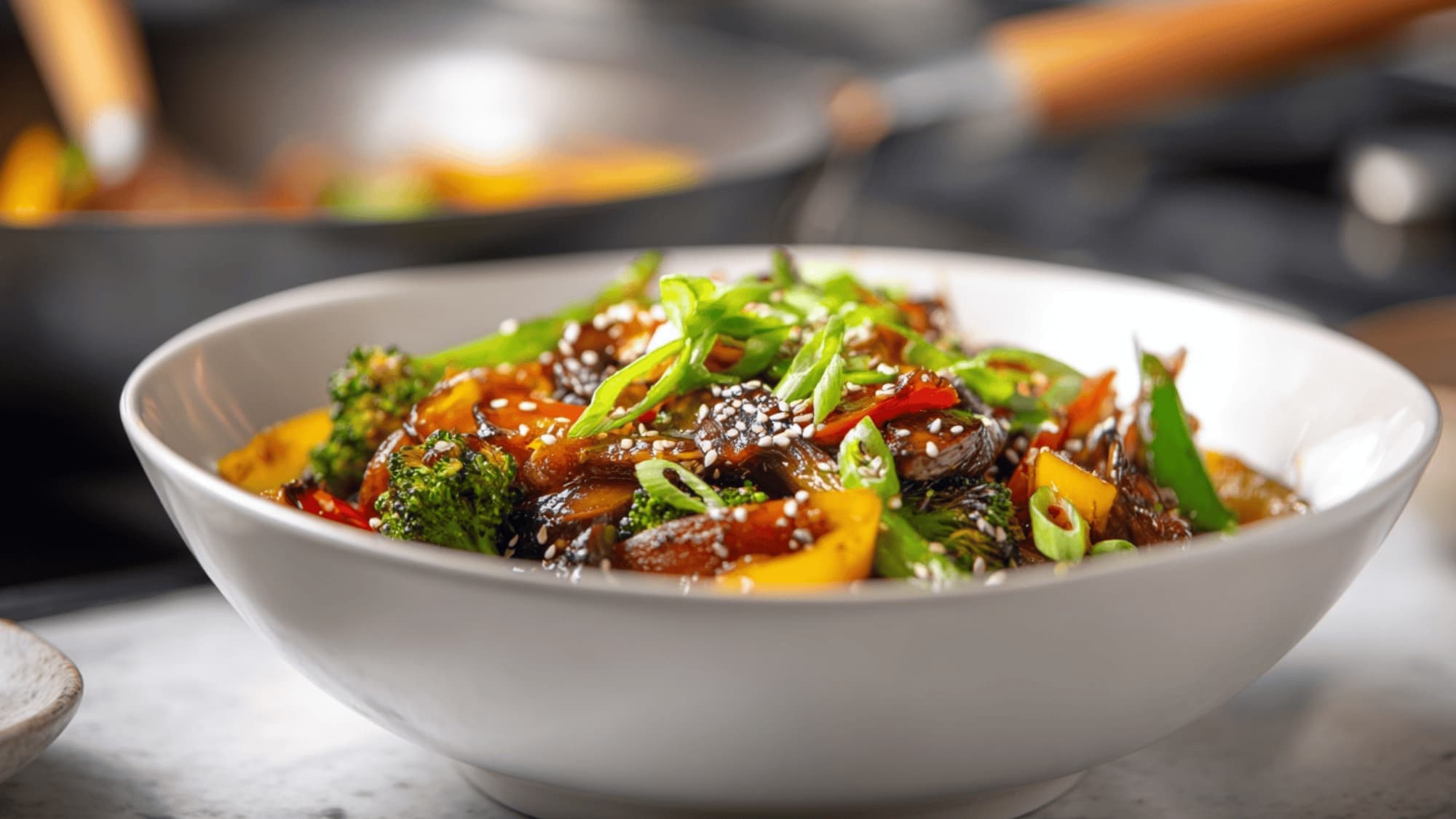 Stir-fried vegetables served in a bowl with sesame seeds and green onions
