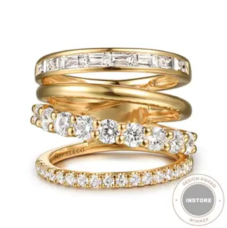Stacked gold engagement rings with diamond settings on a white background
