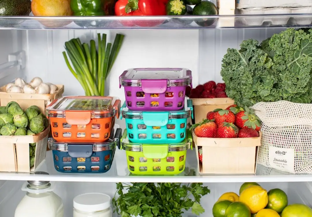 Colorful storage containers with fresh vegetables and fruits in a well-organized refrigerator