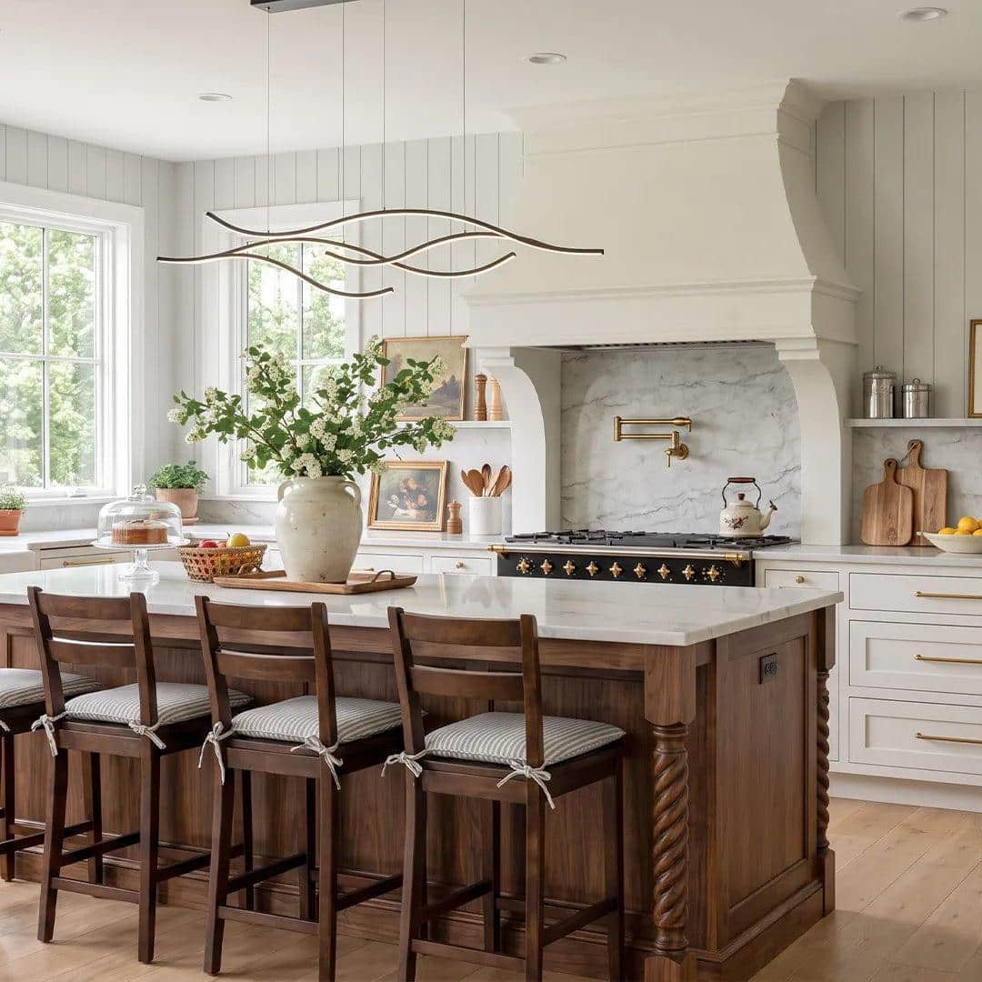 Spacious kitchen with wooden island, bar stools, and decorative range hood under natural light