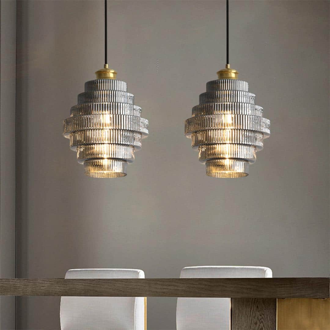 Art deco pendant lights hanging over wooden dining table with white chairs in modern interior