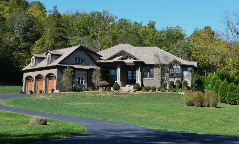 A large modern house with a garage and green lawn.