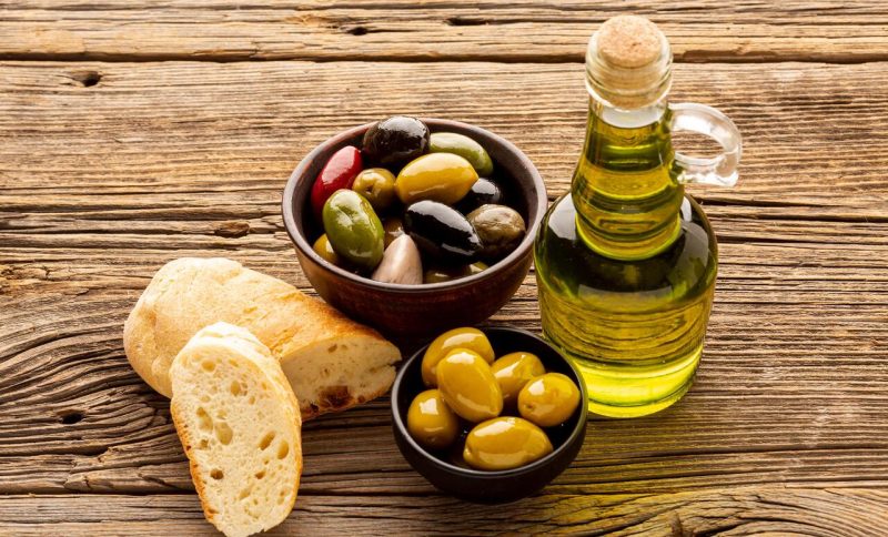 high-angle-olive-bowls-bread-slices-oil-bottles__1_