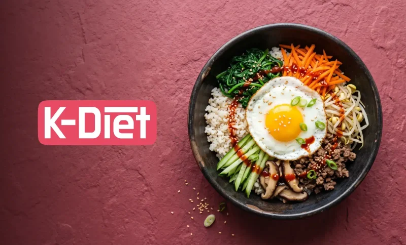 Korean bibimbap with fried egg, vegetables, and rice in a black bowl on textured red background